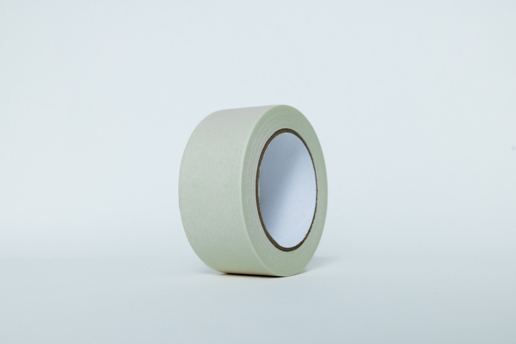 Roll of green tape on a light gray background