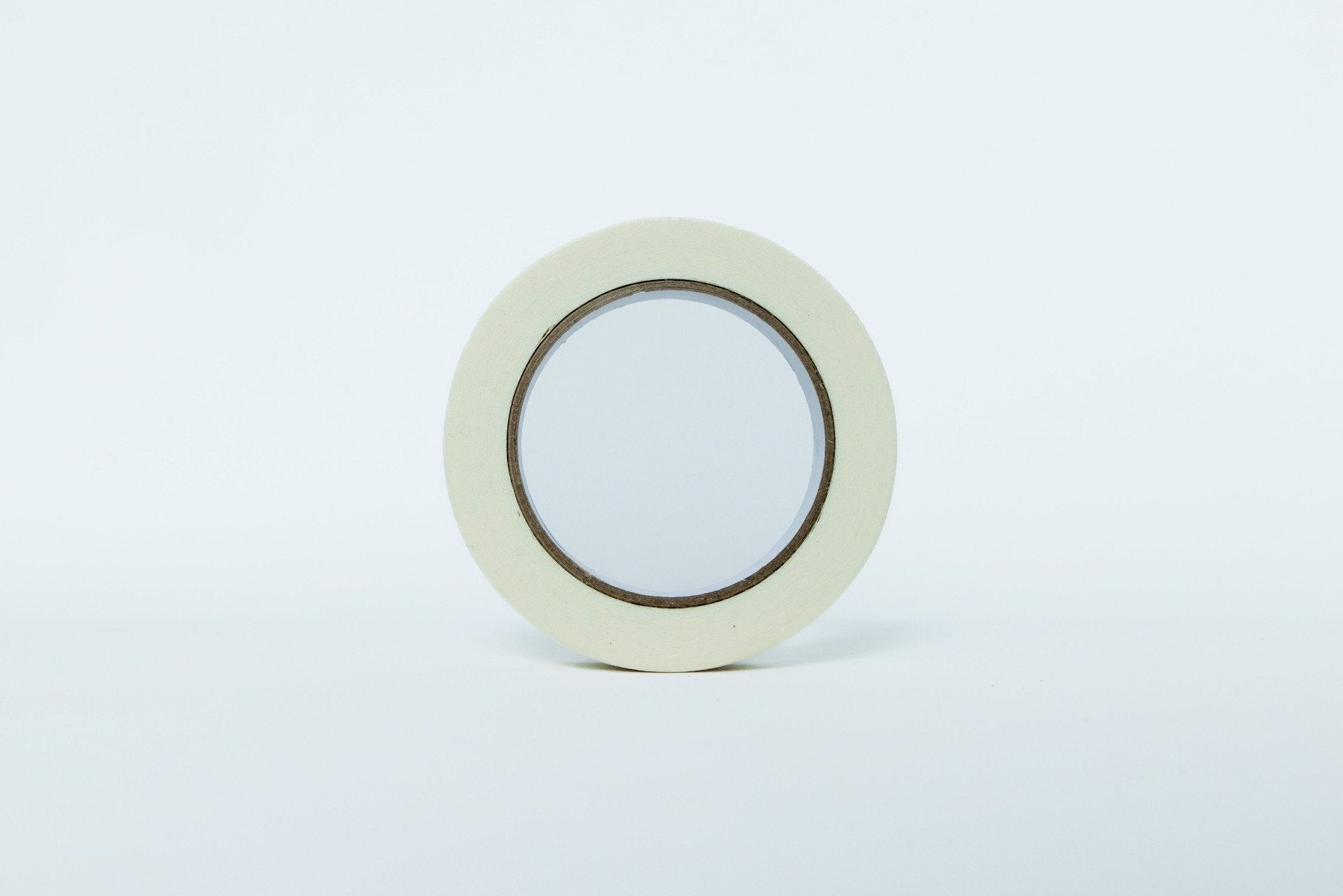 Roll of white tape on a light gray background