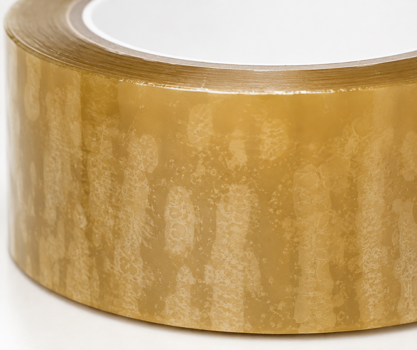 Close-up of yellowish hybrid adhesive packaging tape roll with BOPP film