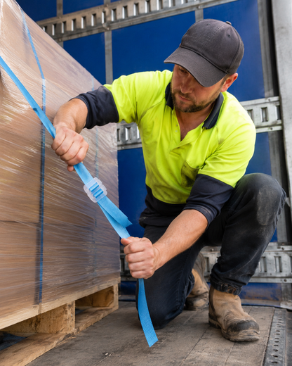 Worker using a self-locking 15mm plastic buckle to tension and secure a polypropylene strap.