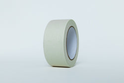 Roll of green painter's tape on a light gray background
